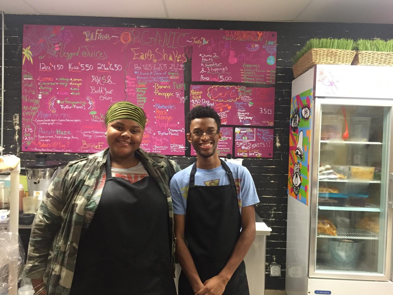 Menu Madness   Owner Tonina Davis and employee Shawn LaBon are in front of the vegan menu. Be Free is filled with multiple art pieces and some are for sale.