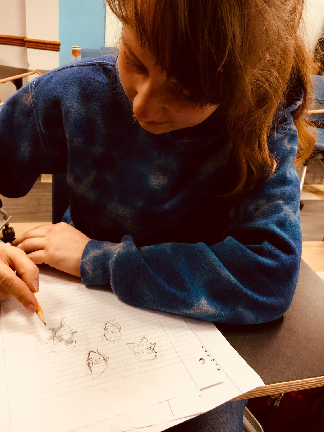 Artistic endeavors Junior Rebecca May (left and right) sketches out faces on a scrap piece of notebook paper. The next edition of EDDA comes out towards the end of April.