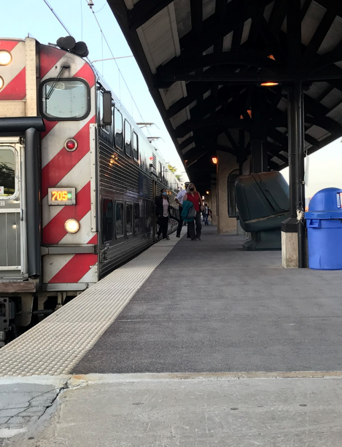Commuters exit the Metra at the Homewood train station in tight groups with their companions to socially distance while also wearing masks.