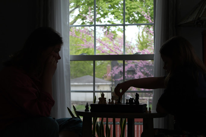 Katherine, left, plays chess with my little sister, right. 
