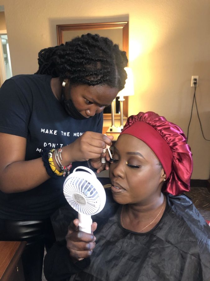 Senior Jane Akpan applying make-up on one of her clients. 