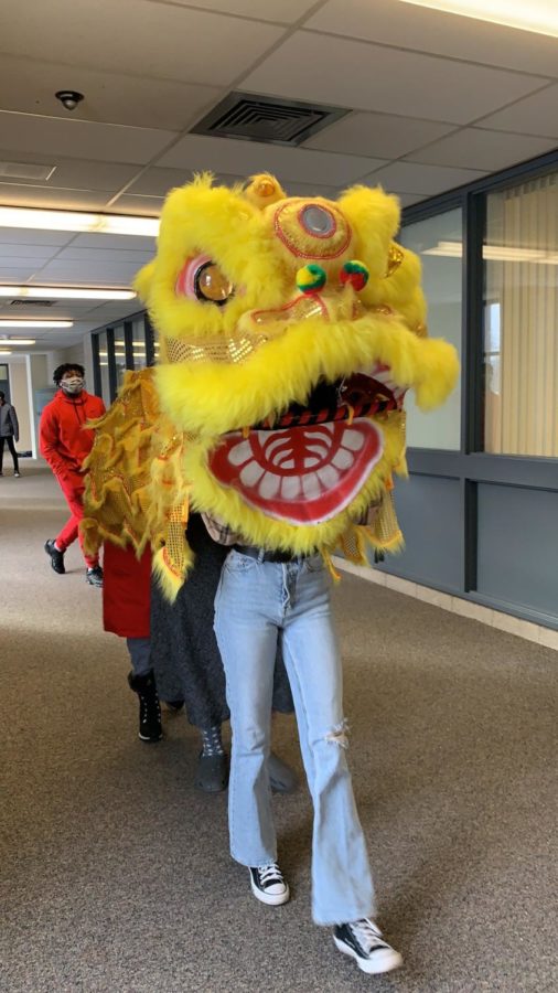 Yin Dings second period class walking around H-Fs north building with a ceremonial dragon.