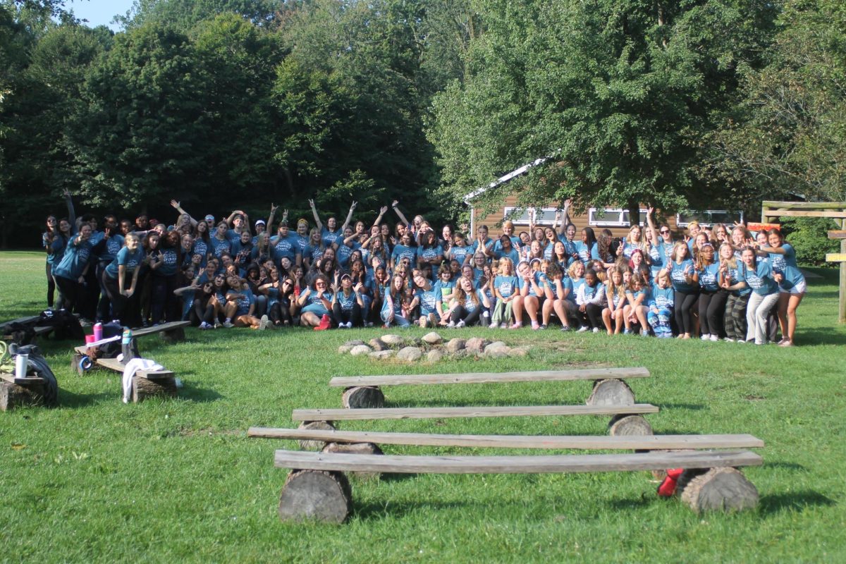 All campers gather around the front of their cabins for a big group photo!