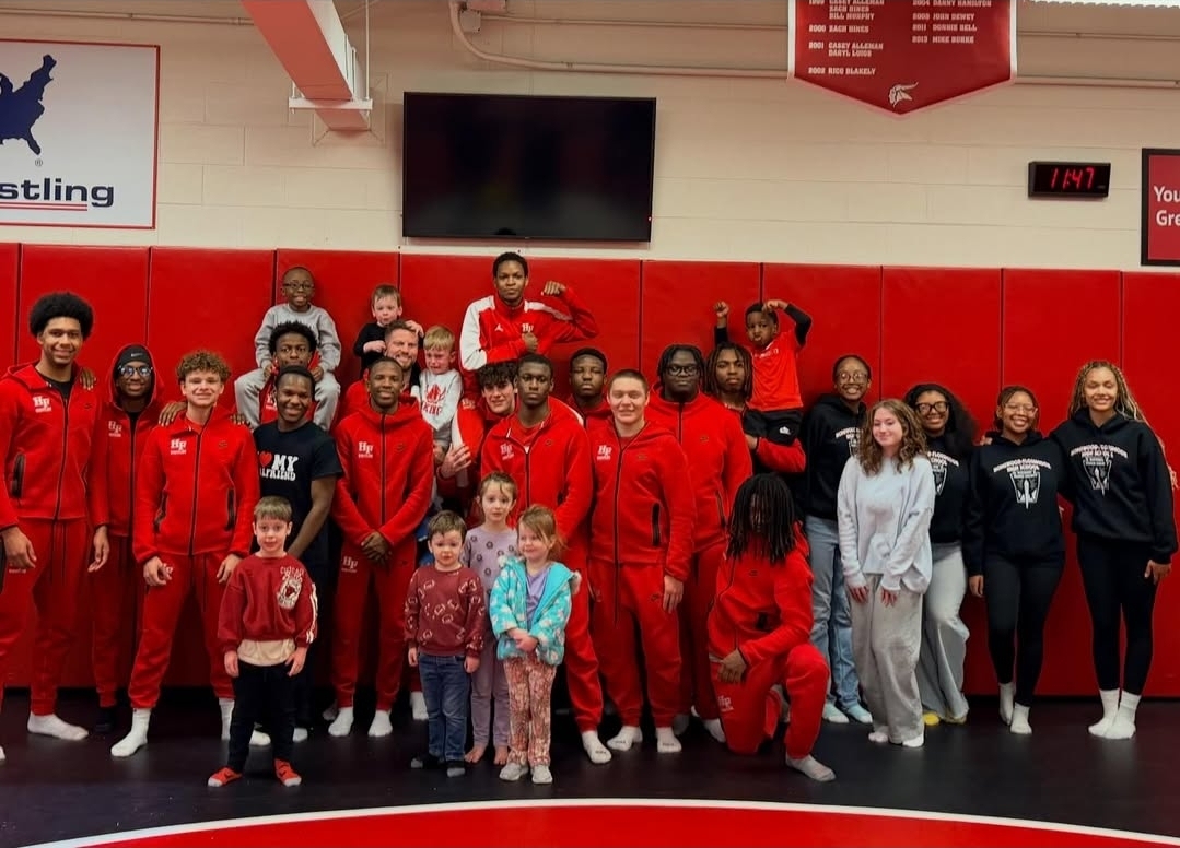 Wrestlers pose with kids after reading to them.  